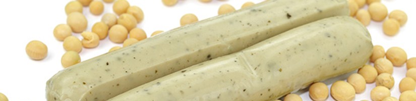 Zwei vegetarische Würste umrahmt von Sojabohnen.