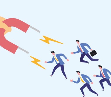 Eine Hand hält einen Magneten, der Beschäftigte anzieht.