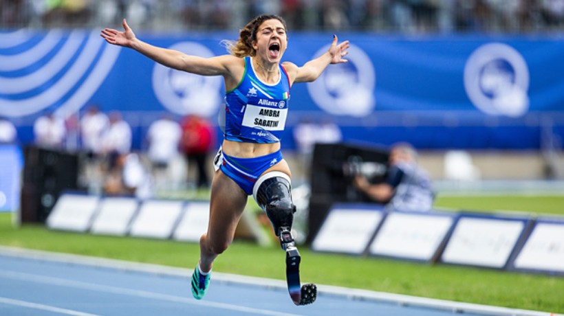Das Foto zeigt die italienische Läuferin Ambra Sabatini. Sie läuft mit einer Beinprothese am linken Bein, reißt die Arme zur Seite und schreit vor Begeisterung.